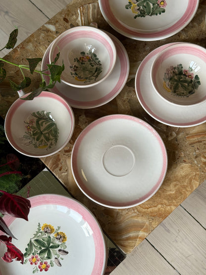 Thesæt med lyserød kant og blomster
